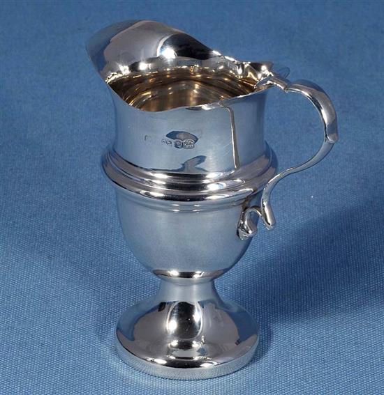 A late Victorian silver cream jug, by William Davenport and a sugar caster.